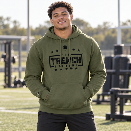 Lifestyle view of Trench Hold the Line Military Green Hoodie at an athletics setting.