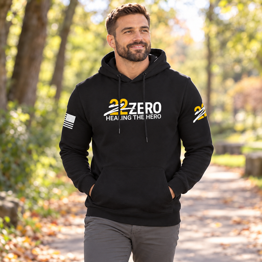Healing the Hero Black Hoodie worn by an adult man in a leafy park path on a clear cool morning; front view.
