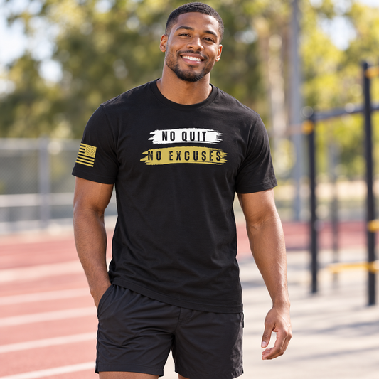 No Excuses Black Tee worn by an adult man in a sunlit outdoor training court, softly blurred track and trees; front view.
