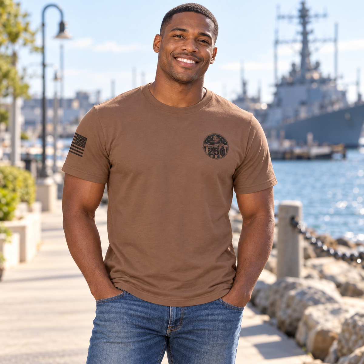 Lifestyle view of Navy 250th Birthday Coyote Brown Tee outdoors.
