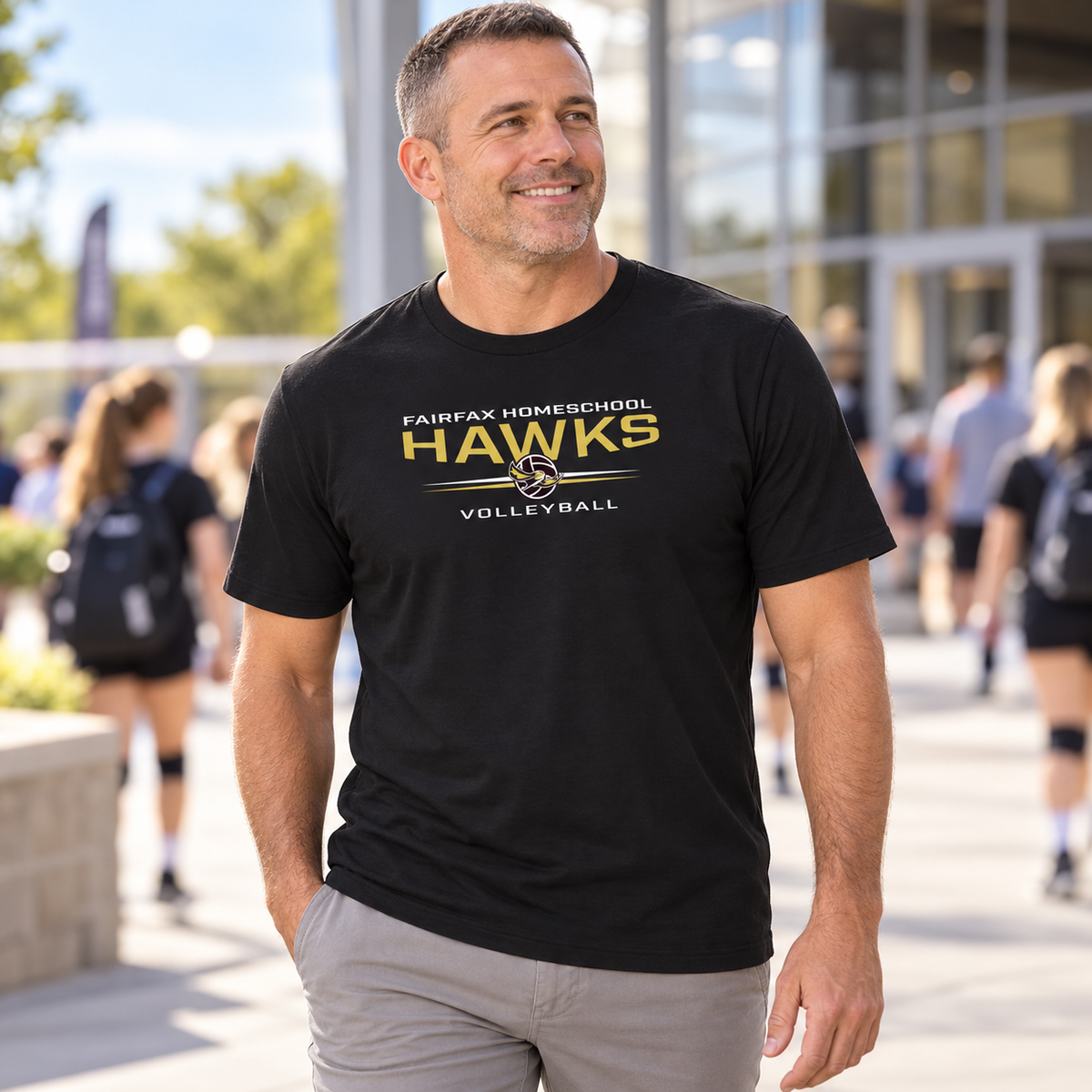 FHS Volleyball Tee worn by an adult man in a community sports-center walkway outside a volleyball venue; front view.