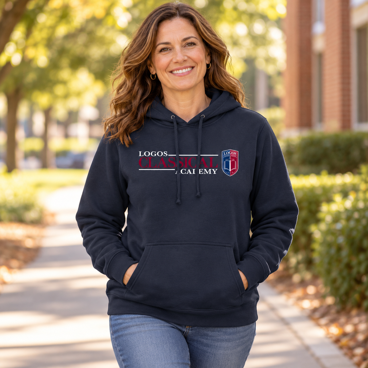 LCA Hoodie worn by an adult woman in a tree-lined school walkway in warm afternoon daylight; front view.