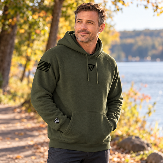 Men's Freedom Is Not Free Hoodie worn by an adult man in a tree-lined lakeside walking path in soft early autumn light; front view.