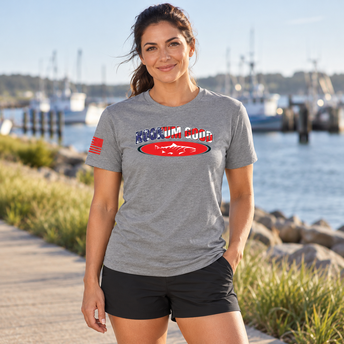 Woman wearing the gray Hookum Good Flag Tee by the waterfront.