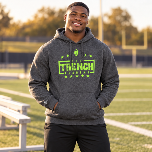 Man wearing the Trench Hold the Line Charcoal Hoodie at a football field.