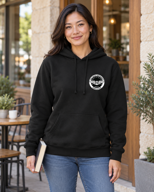 Woman wearing the black AFSA Crest Hoodie with white left-chest seal outside a cafe.